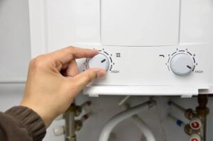 Homeowner adjusting tankless water heater temperature setting